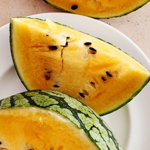 Yellow Watermelon sliced displayed on a plate.